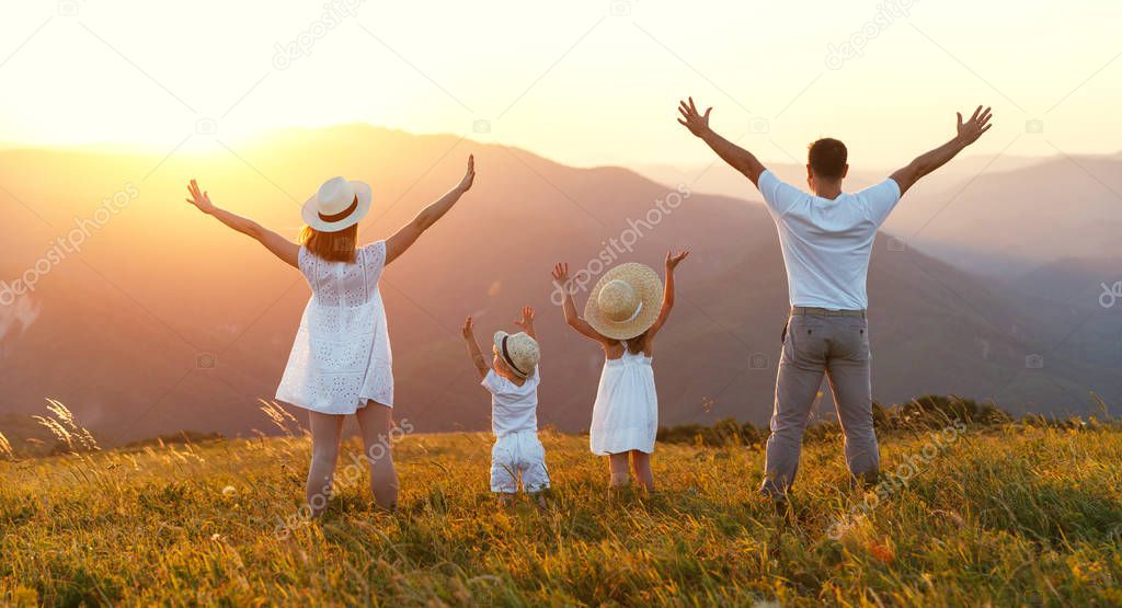 Happy family: mother, father, children son and  daughter on nature  on sunse