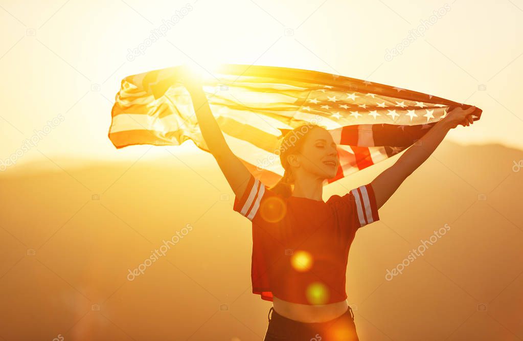 young happy woman with flag of united states enjoying the sunset on natur