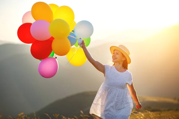 一个年轻快乐的女人在日落时拿着气球 — 图库照片