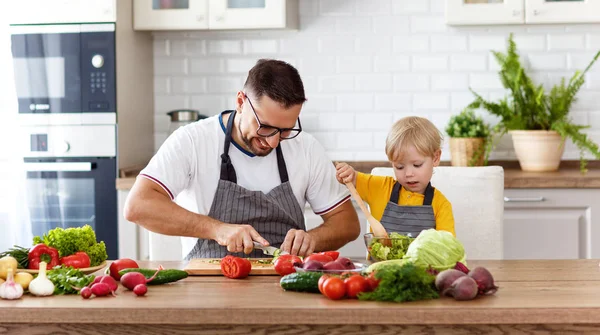 幸福的家庭父亲与儿子准备蔬菜沙拉在磡 — 图库照片