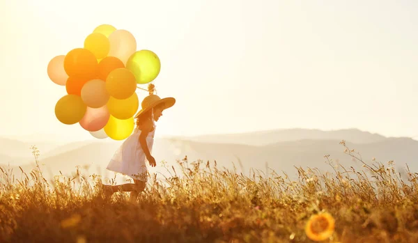 年轻快乐的孩子女孩与气球在日落在炎炎夏日 — 图库照片