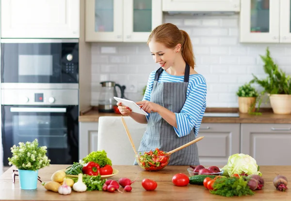 Mutlu Kadın Bir Tabloyla Reçete Üzerinde Mutfakta Sebze Hazırlama — Stok fotoğraf