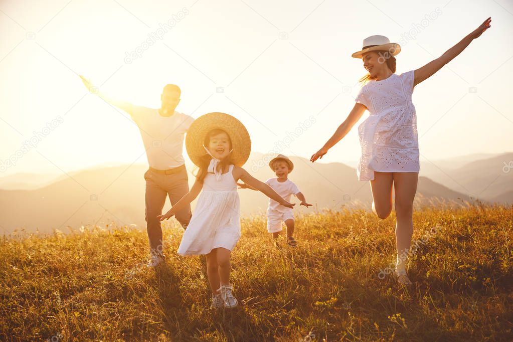 Happy family: mother, father, children son and  daughter on nature  on sunset