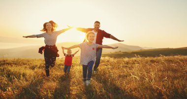 Mutlu bir aile: Anne, baba, çocuk oğlu ve kızı sunse doğa üzerine