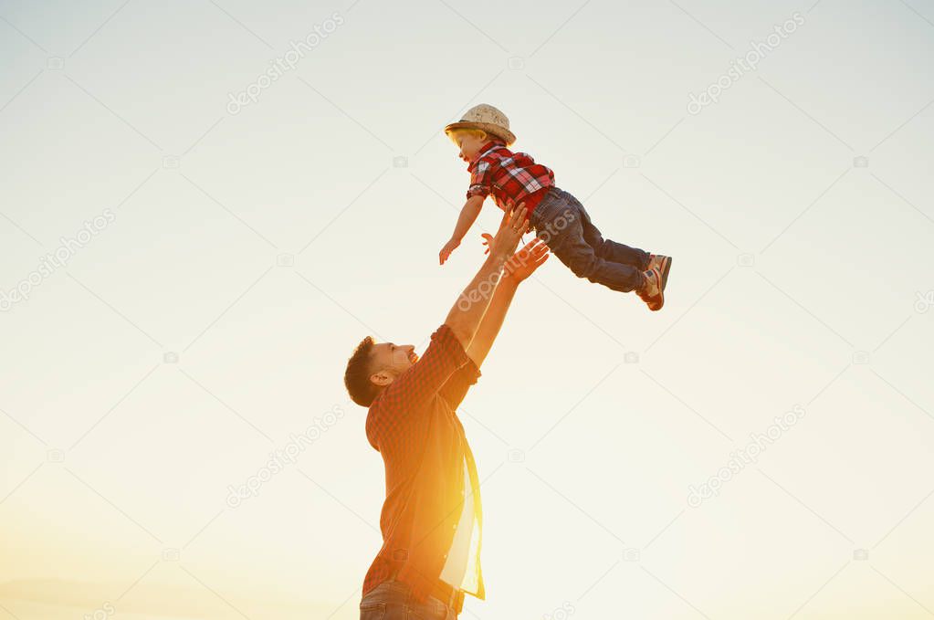 Father's day. Happy family father and toddler son playing and laughing on nature at sunse