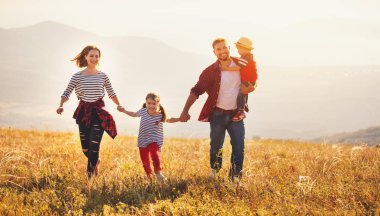 Mutlu bir aile: Anne, baba, çocuk oğlu ve kızı sunse doğa üzerine