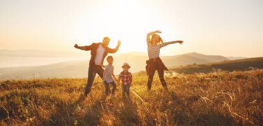 Mutlu bir aile: Anne, baba, çocuk oğlu ve kızı sunse doğa üzerine