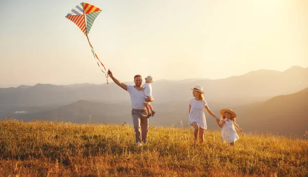 快乐的家庭父亲 母亲和孩子们在日落时分放风筝 — 图库照片