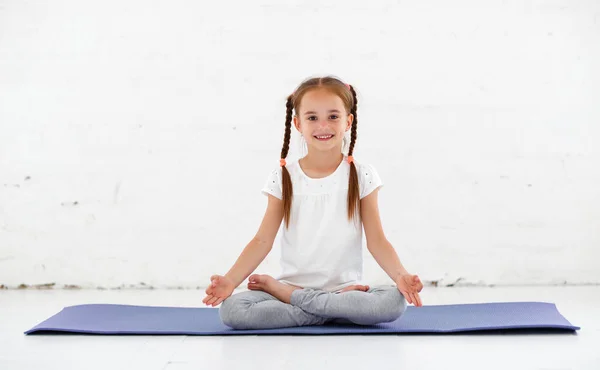 Child girl doing yoga and gymnastics in the gy — Stock Image Child Girl Doing Yoga Gymnastics Royalty Free Stock Photos