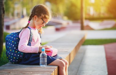 liseli kız çocuk okuldan öğle yemeği elma ve muz yeme