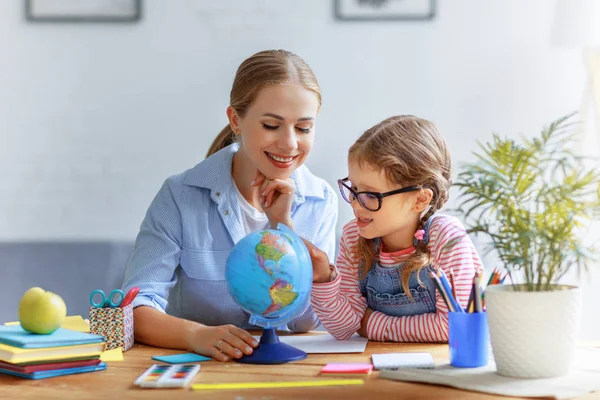 Mutter Und Tochter Bei Hausaufgaben Geografie Mit Globus Hom — Stockfoto
