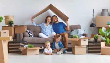 mutlu aile anne baba ve çocuk yeni bir eve taşınmak ve kutusu used açmak