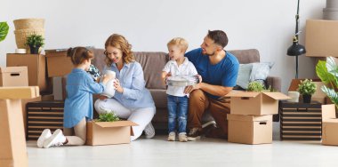 mutlu aile anne baba ve çocuk yeni bir eve taşınmak ve kutusu used açmak