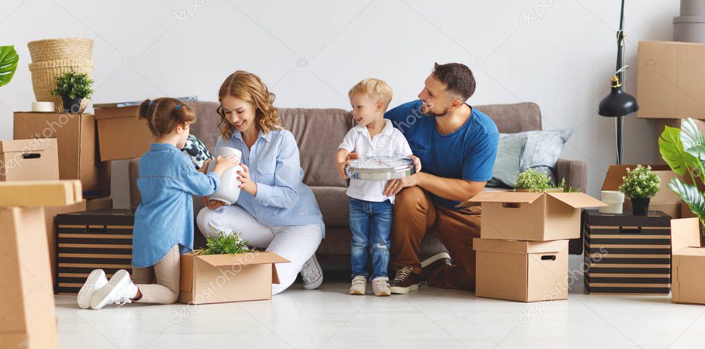 happy family mother father and children move to a new apartment and unpack boxe