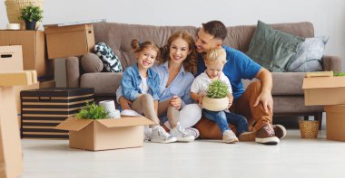 mutlu aile anne baba ve çocuk yeni bir eve taşınmak ve kutusu used açmak