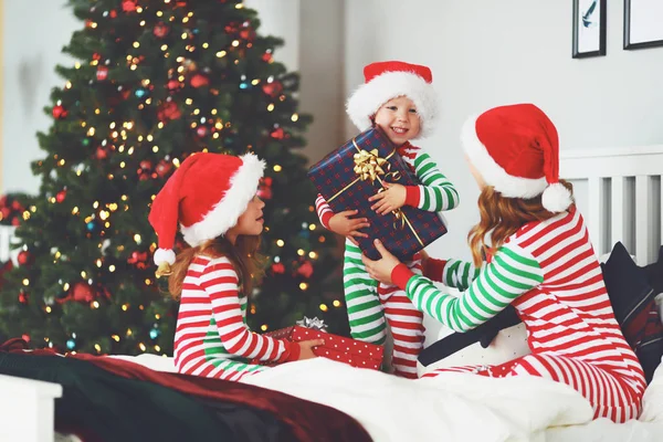 幸福的家庭母亲和孩子在睡衣打开礼物在圣诞节早晨附近的圣诞节 — 图库照片