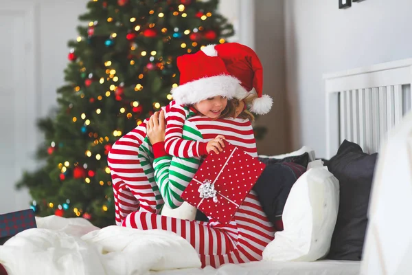 Gelukkige Familie Moeder Knuffel Haar Zoontje Pyjama Geschenken Openen Kerstochtend — Stockfoto