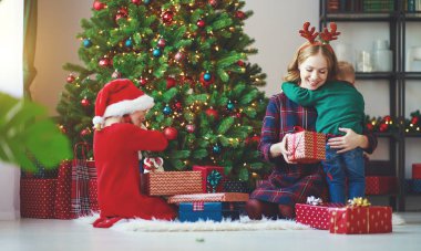 mutlu aile anne ve çocuk armağan üstünde Noel sabah aç