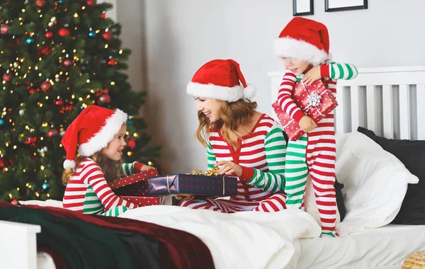 幸せな家族母親と子供クリスマス トレ近くクリスマスの朝にプレゼントを開くのパジャマを着て — ストック写真