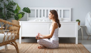 Genç güzel kız hom lotus pozisyonunda yoga yapıyor