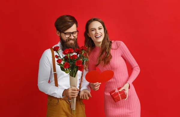 情人节的概念 幸福的年轻夫妇与心脏 礼物在红色背景 — 图库照片