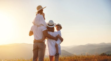 Mutlu bir aile: Anne, baba, çocuk oğlu ve kızı sunse doğa üzerine