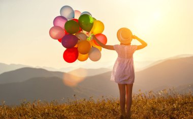 Balonlar summe batımında olan mutlu kadın