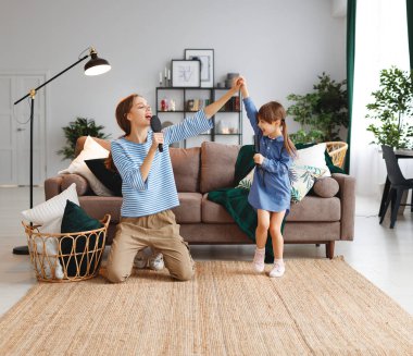 mutlu aile anne ve çocuk kızı evde oynamak ve tarak ile şarkı
