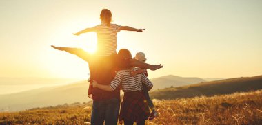 Mutlu bir aile: Anne, baba, çocuk oğlu ve kızı sunse doğa üzerine