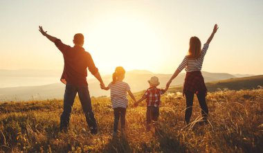 Mutlu bir aile: Anne, baba, çocuk oğlu ve kızı sunse doğa üzerine