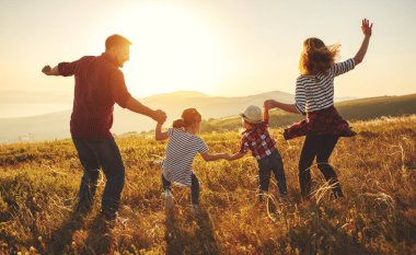 Mutlu bir aile: Anne, baba, çocuk oğlu ve kızı sunse doğa üzerine