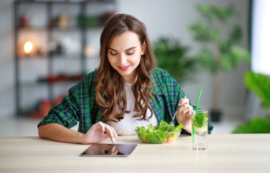 sağlıklı beslenme. kitche sabah tablet pc ile salata yiyerek mutlu genç kız