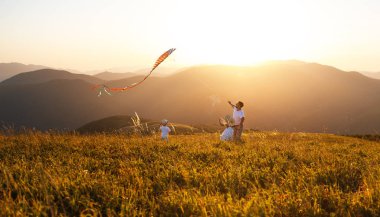 Mutlu aile baba ve çocuk doğa sunse adlı bir uçurtma başlatmak