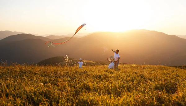 幸せな家族の父と子供たち Sunse で自然にカイトをランチングします — ストック写真