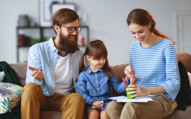 mutlu aile anne baba ve çocuk kız evde couc üzerinde çizmek