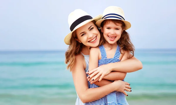 Familia feliz en la playa. madre e hija abrazo al atardecer —  Fotos de Stock