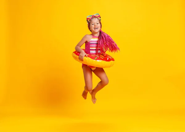 Ευτυχισμένο παιδί κορίτσι στο μπανιερό με κολύμβηση δακτύλιο ντόνατ στο χρώμα — Φωτογραφία Αρχείου