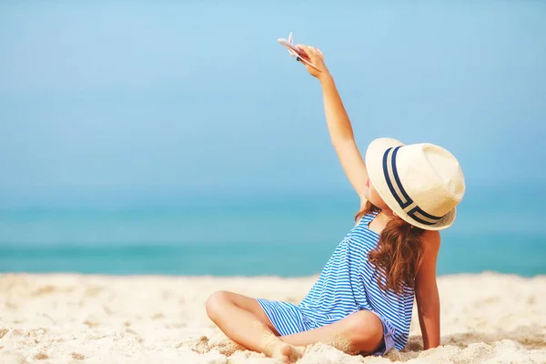 Barn tjej med leksak modellflygplan havet på stranden — Stockfoto