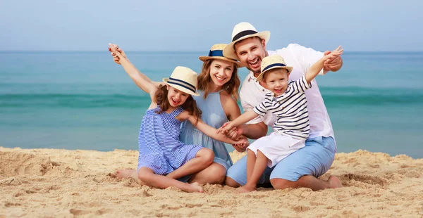 Happy family father, mother and children on beach at sea — Stock Photo, Image