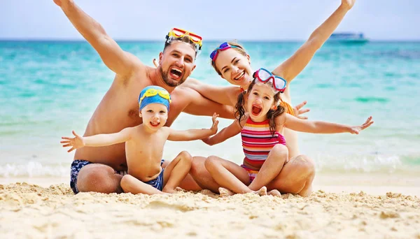 Feliz familia padre, madre e hijos en la playa en el mar — Foto de Stock