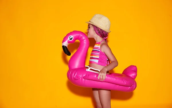 . menina feliz em maiô com flamingo anel de natação em co — Fotografia de Stock