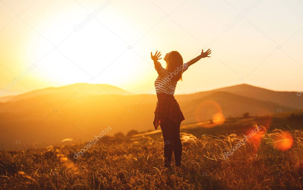 Happy woman jumping and enjoying life  at sunset in mountain