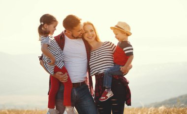 Mutlu bir aile: Anne, baba, çocuk oğlu ve kızı sunse üzerine