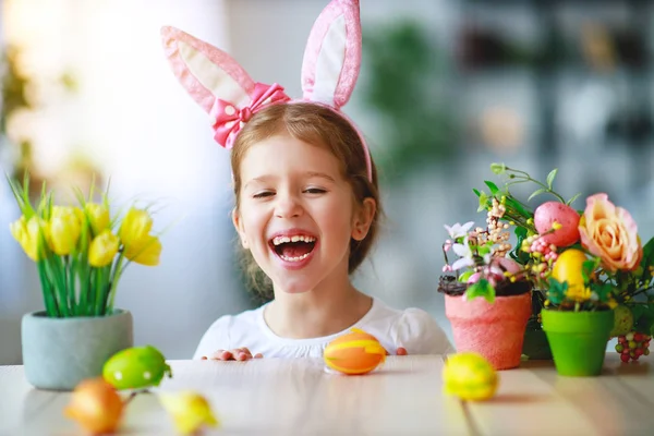 Happy easter! funny child girl with rabbit ears and eggs