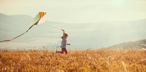 Щаслива дитина дівчина біжить з повітрям на заході сонця на відкритому повітрі — стокове фото