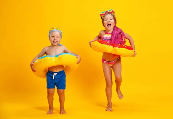 Niña y niño feliz en traje de baño con anillo de natación donut — Foto de Stock