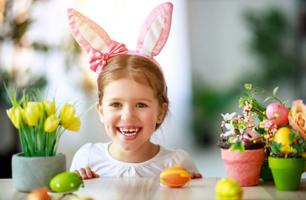 Vrolijk Pasen! grappige kind meisje met konijnen-oren en eieren — Stockfoto
