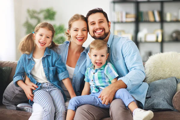 Família feliz mãe pai e filhos em casa no sofá — Fotografia de Stock