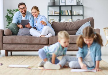 mutlu aile anne baba ve çocukların birlikte evde çizmek 