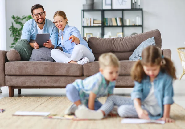 Lyckliga familjen mamma, pappa och barn rita tillsammans hemma — Stockfoto